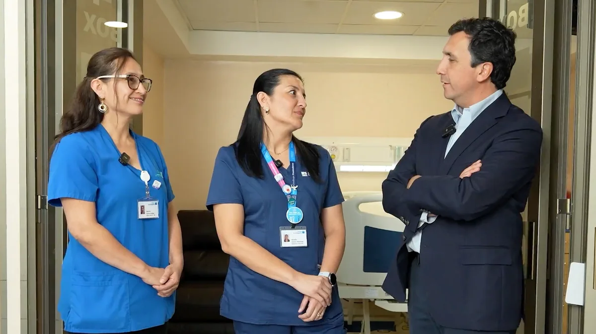 Rafael Córdova conversando con dos profesionales de salud en una clínica Bupa