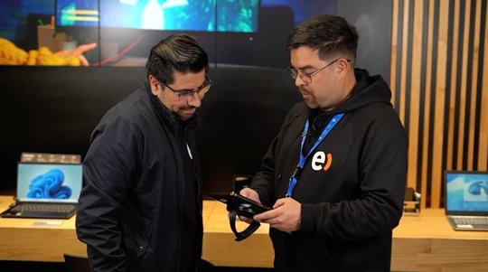 Dos colaboradores revisando un dispositivo en el mostrador